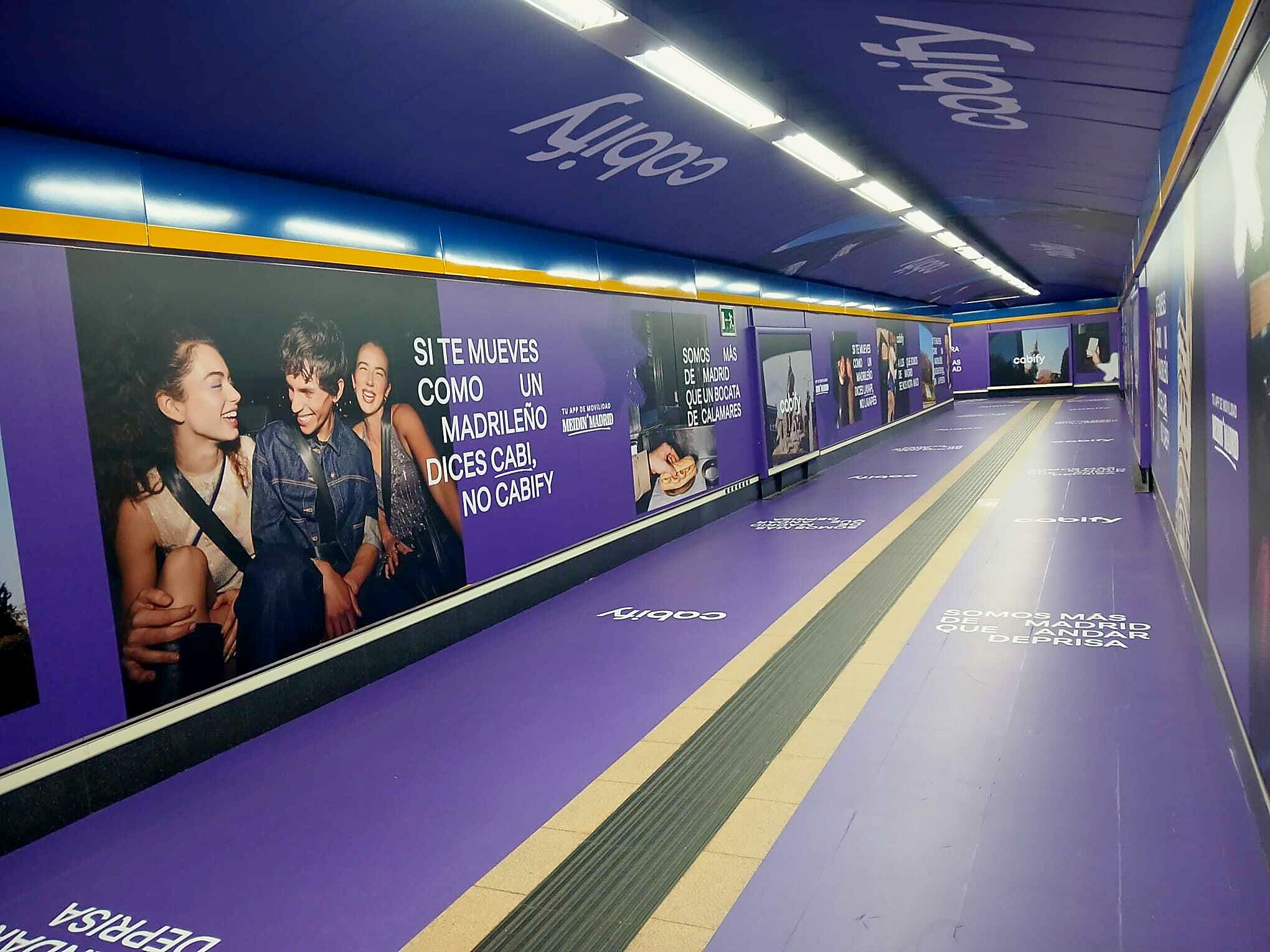 Long corridor with large-format photography of people riding Cabify