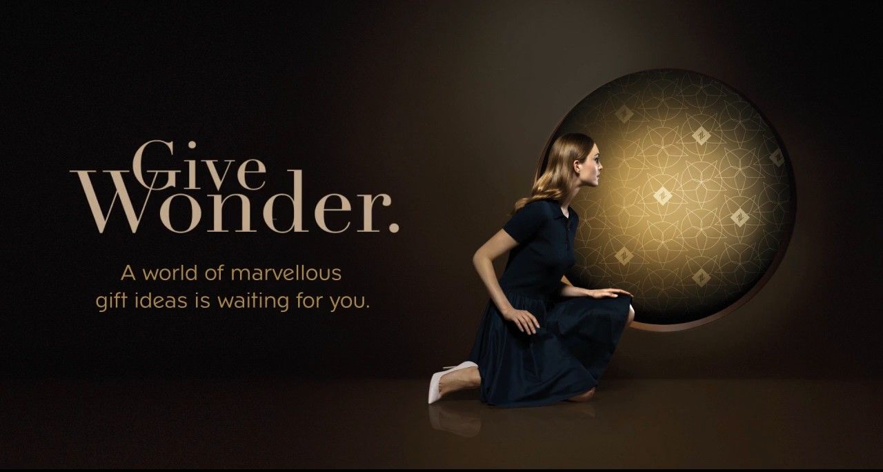 Give Wonder: a woman looks into a golden sphere